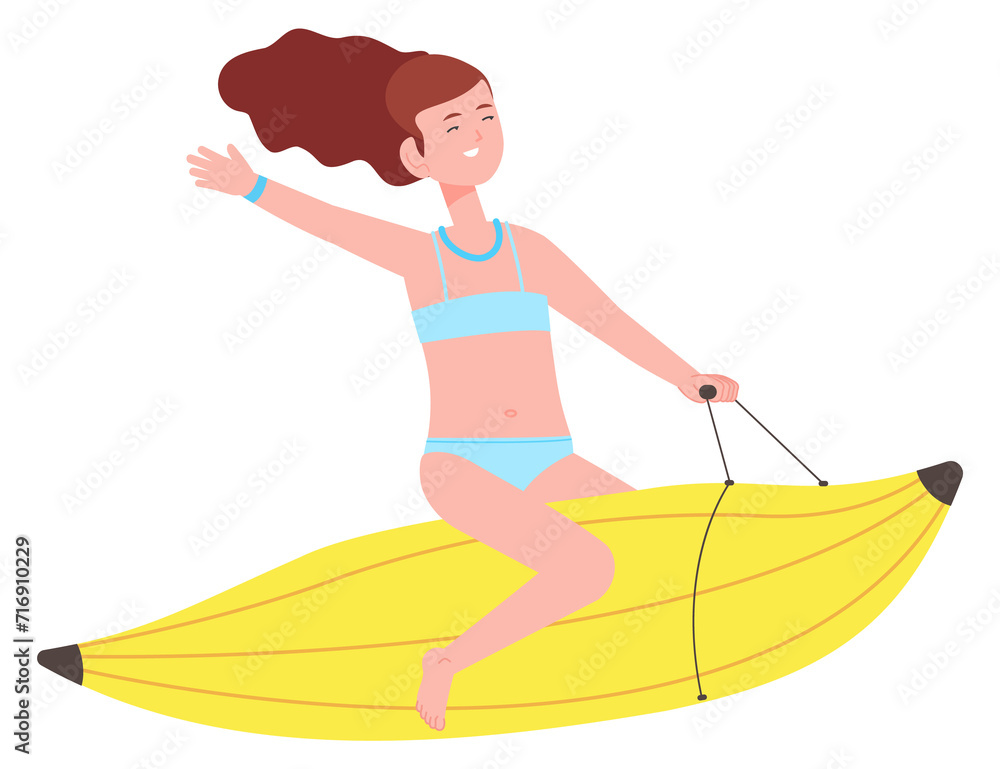 Laughing girl riding banana boat. Summer activity