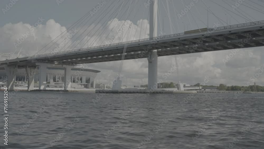 A cable-stayed road bridge in St. Petersburg with the Zenit Arena stadium in the background. View from the Neva River A cable-stayed road bridge in St. Petersburg with the Zenit Arena stadium in the background. View from the Neva River