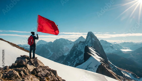 A man holding a red flag on the mountain. Symbolize success and achieve the goal.