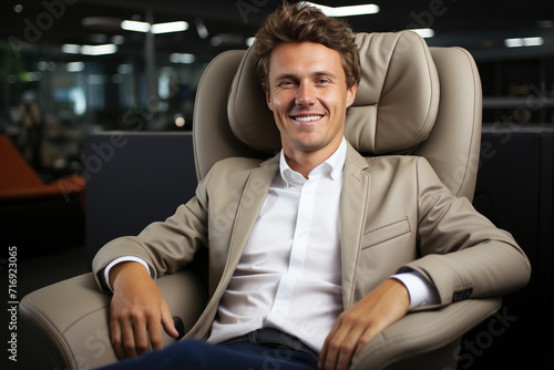 Portrait of handsome smiling businessman sitting in an armchair