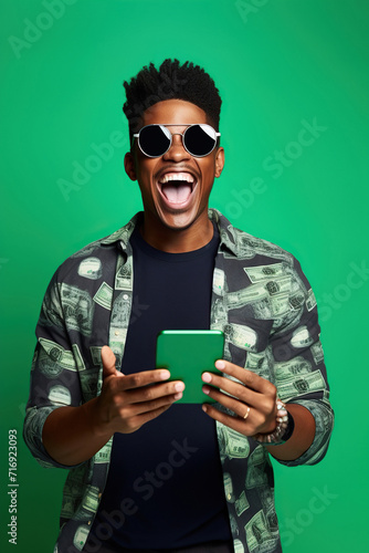 Portrait of overjoyed impressed African American person wear stylish t-shirt eyewear holding smartphone win betting isolated on green color background