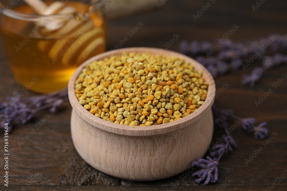 Fresh bee pollen granules in bowl, lavender and honey on wooden table, closeup Fresh bee pollen granules in bowl, lavender and honey on wooden table, closeup