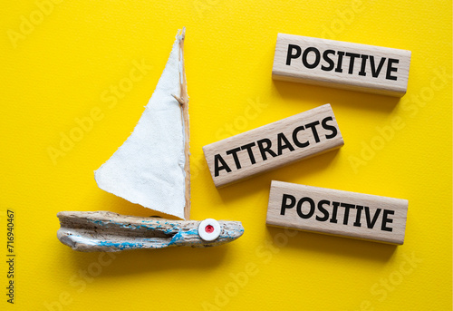 Positive attracts Positive symbol. Wooden blocks with words Positive attracts Positive. Beautiful yellow background with boat. Business and Positive attracts Positive concept. Copy space. photo