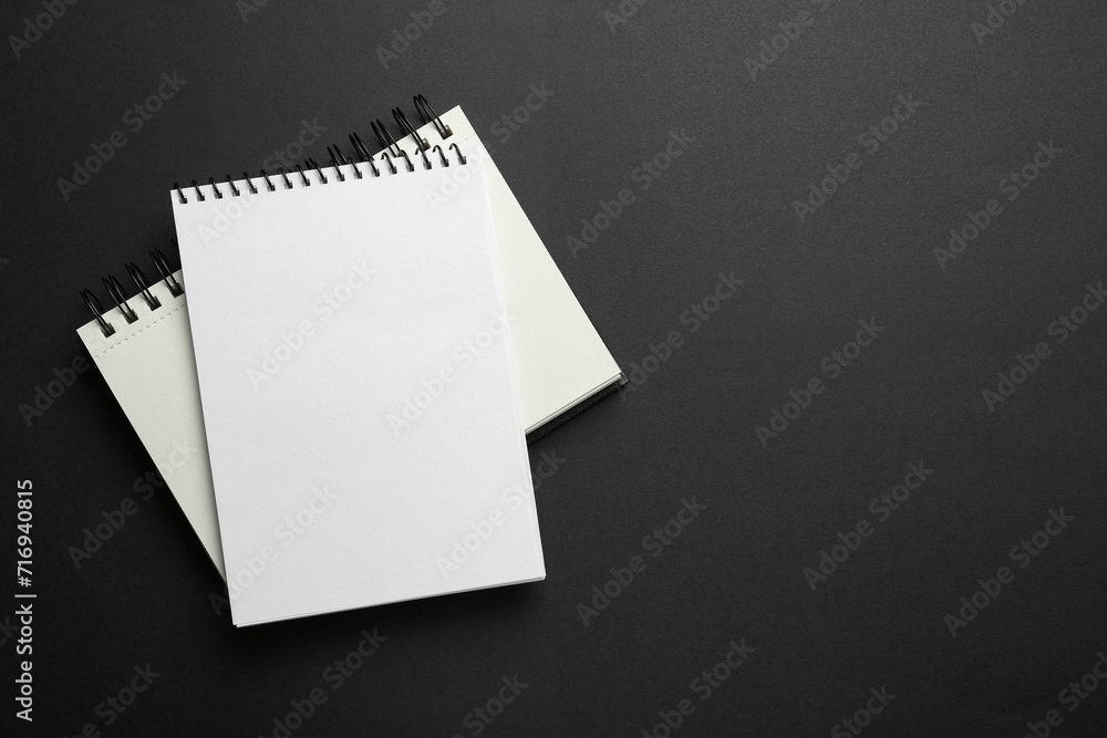 Notebooks on black background, top view. Space for text Notebooks on black background, top view. Space for text