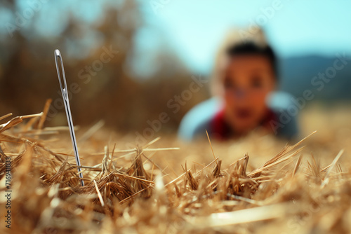 Close-up of a needle in a haystack with a blurred background of a person looking for it with a satisfied face. 