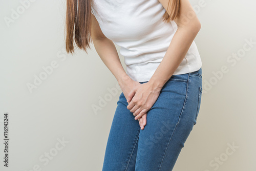 Vaginal, urinary incontinence. Pain asian young woman hand holding crotch suffering from pain, itchy or scratch of vagina, genital itching from infection. Gynecological problems menstrual disorder