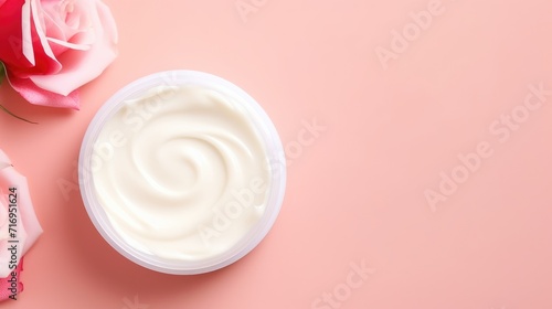 Jar of facial cream and flower roses. Skin care or hair care cosmetics product and rose flower on pink background. Natural beauty products with rose extract for face skin care concept. Space for text