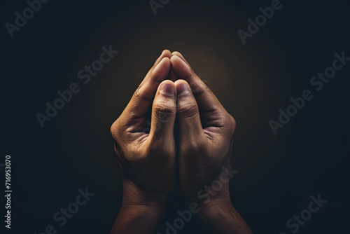Praying hands with faith in religion and belief in God on dark background. Power of hope or love and devotion.