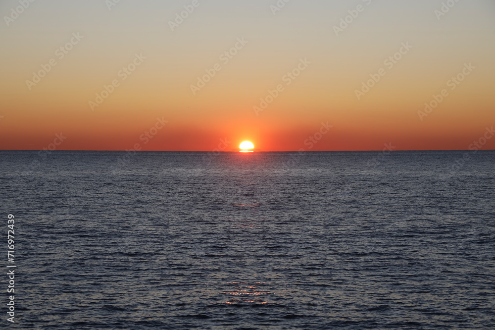 Sun set over Black sea.  Vibrant Sunset above horizon line. Sunset on sea. Bright sun on sky. beach landscape. colorful tropical ocean. sunset background. Batumi, Georgia..