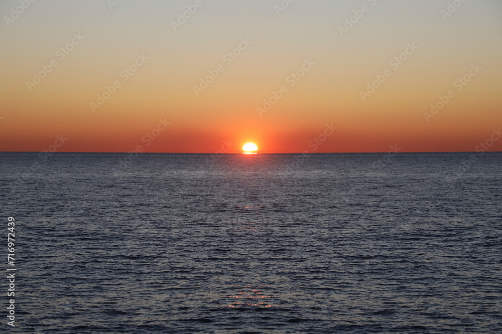 Sun set over Black sea. Vibrant Sunset above horizon line. Sunset on sea. Bright sun on sky. beach landscape. colorful tropical ocean. sunset background. Batumi, Georgia.. Sun set over Black sea. Vibrant Sunset above horizon line. Sunset on sea. Bright sun on sky. beach landscape. colorful tropical ocean. sunset background. Batumi, Georgia..