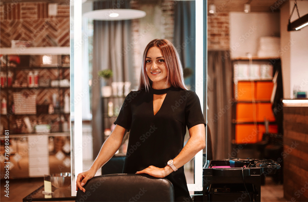 Fototapeta premium Portrait of a young and pretty hairdresser