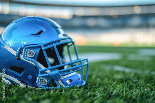Close up of blue american football helmet on green artificial turf stadium.