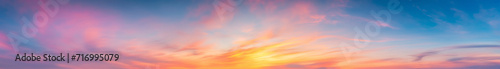 Vibrant extra wide panoramic sky. Fantasy banner sky. Rich colors. Daytime sunset beauty. Fiery glowing heavenly sky with gradient colors. Red, pink, orange, blue, yellow. soft clouds