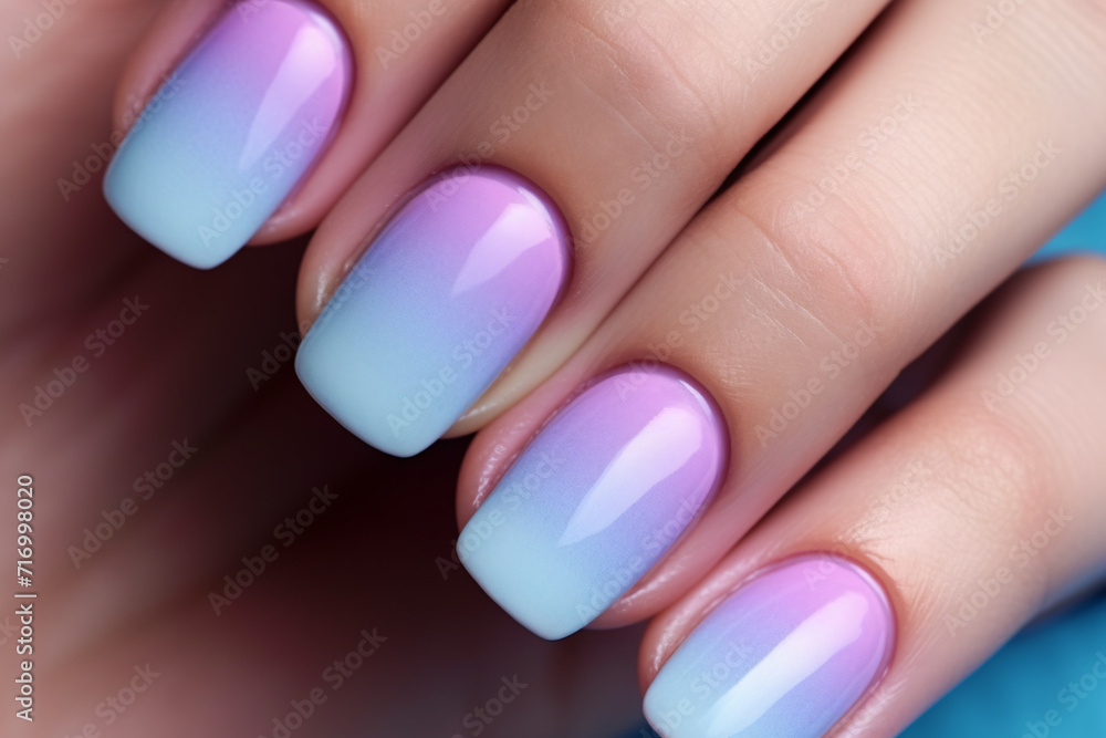 Close up of woman's fingernails with pastel blue and purple ombre colored nail polish design. Close up of woman's fingernails with pastel blue and purple ombre colored nail polish design.