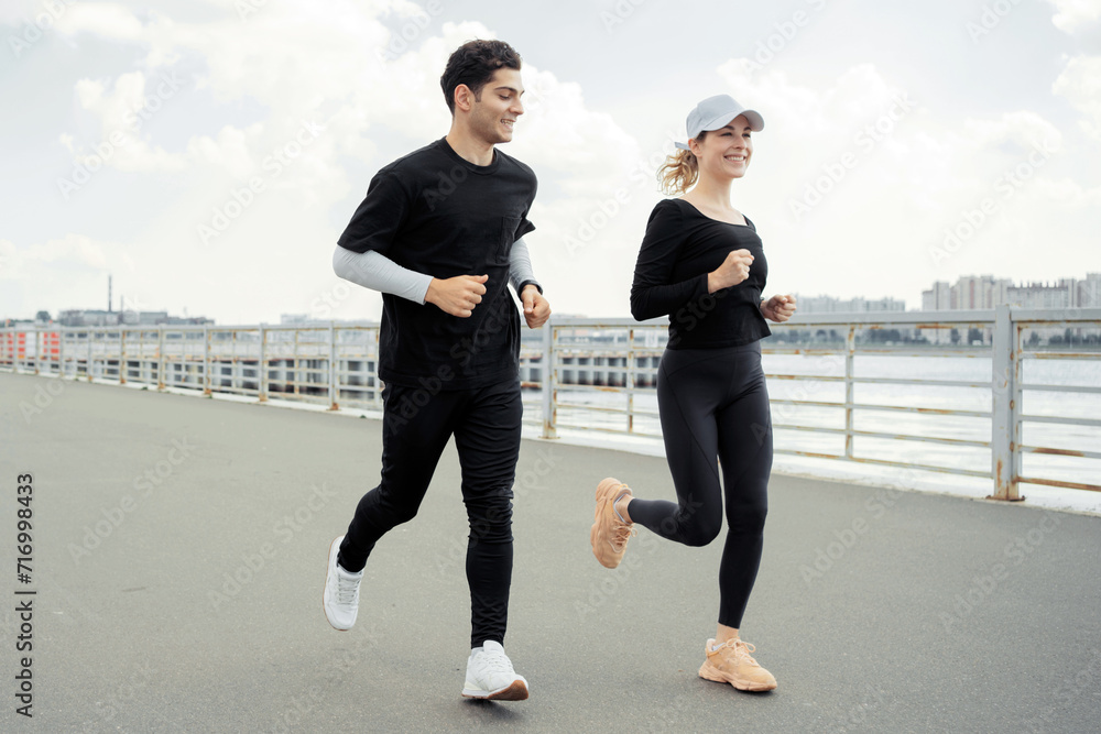 Joyful couple running together on a pier, enjoying a healthy, active lifestyle. Joyful couple running together on a pier, enjoying a healthy, active lifestyle.
