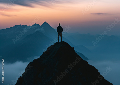 Silhouette of a man on top of a mountain peak © wiizii