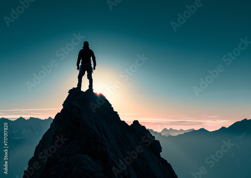 Silhouette of a man on top of a mountain peak