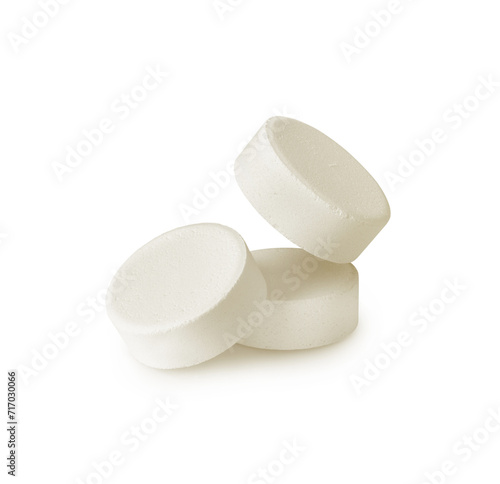 Three soluble tablets isolated on a white background. Effervescent multivitamin pills close-up