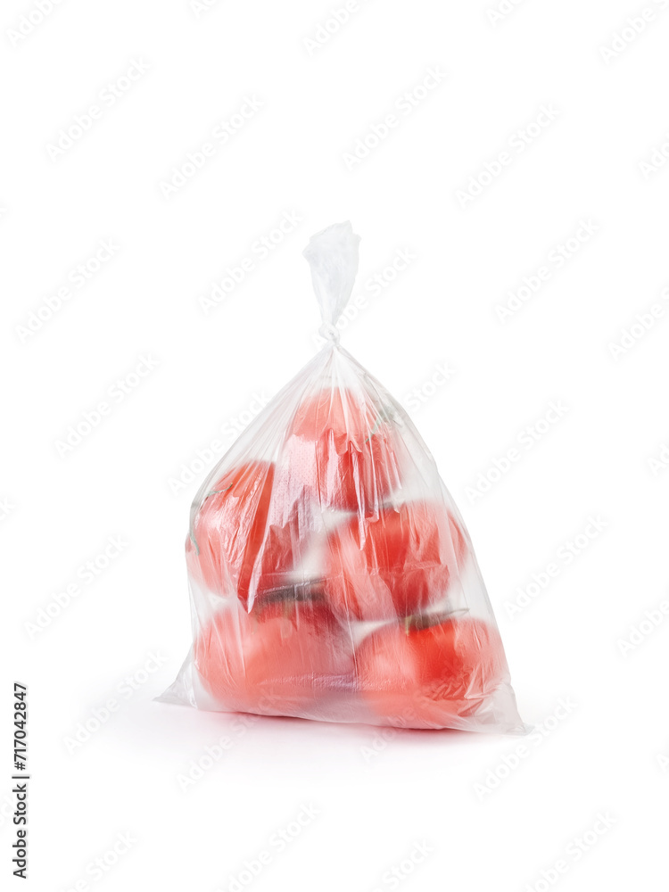 Tomatoes in a closed transparent plastic bag on a white background. Vertical photo. Tomatoes in a closed transparent plastic bag on a white background. Vertical photo.