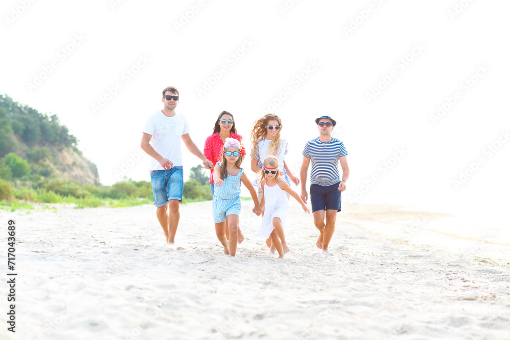 Group of friends with children running at the beach