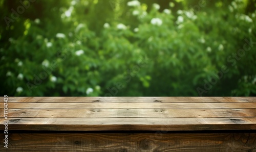 Empty wooden table for product display montages with green nature background.