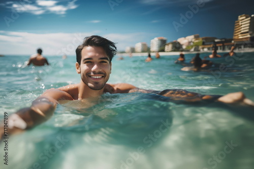  young adult man swimming in the shallow water in the sea on a beach, smiling and happy