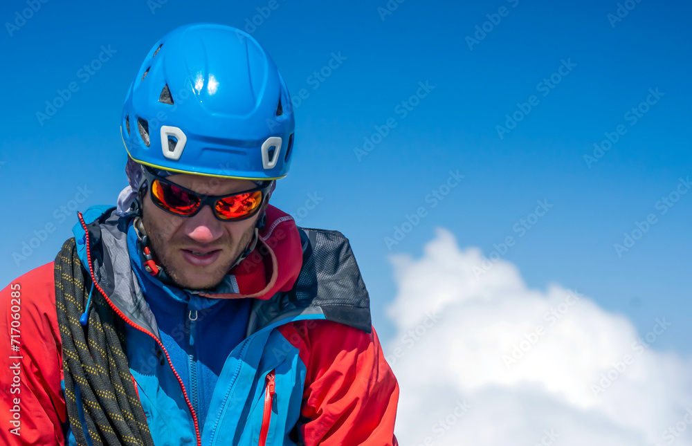 Man with sun glasses is climbing in the mountains.