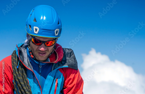 Man with sun glasses is climbing in the mountains.