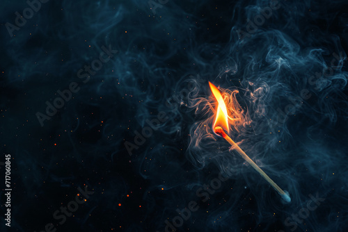Smouldering Matchstick with Smoke.
A matchstick with a smouldering flame enveloped in swirling smoke. photo