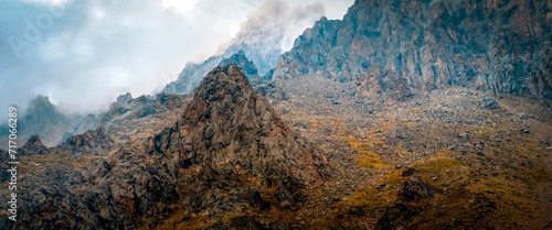 A beautiful rocky mounains in a foggy cloudy weather in the evening. photo