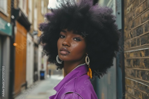 black young attractive woman model wearing a purple outfit with large black Afro hair out on london street, coiffure, coiffure femme