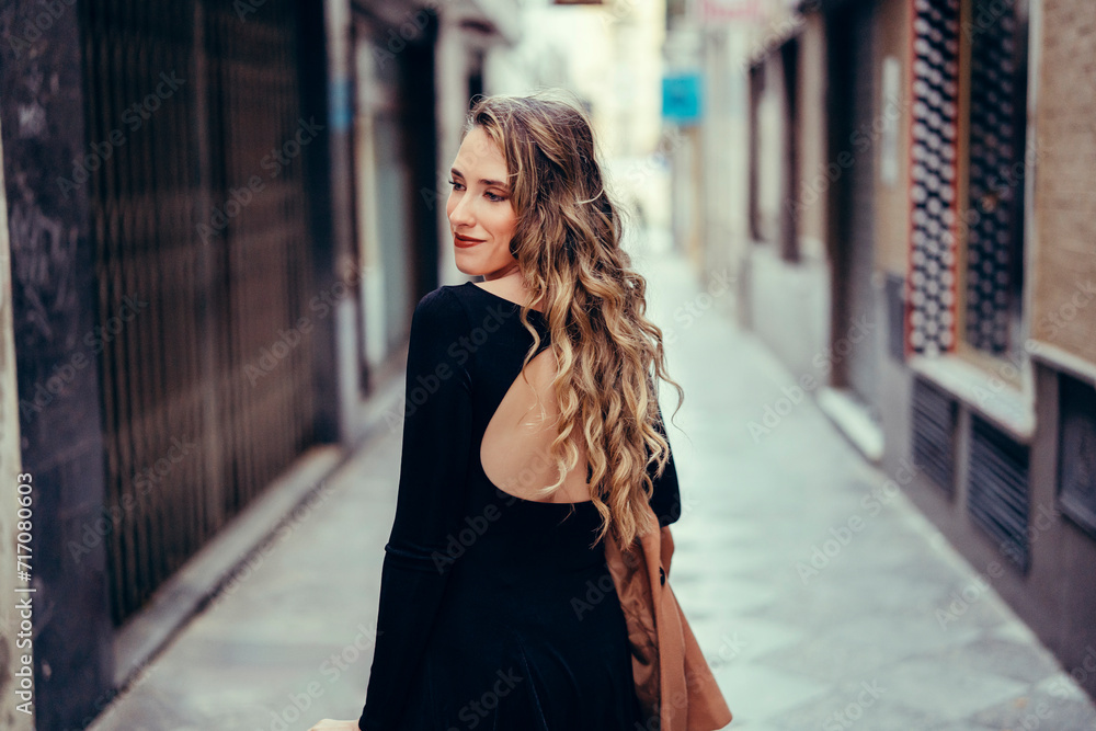 Chica joven con pelo rizado posando en la calle Chica joven con pelo rizado posando en la calle