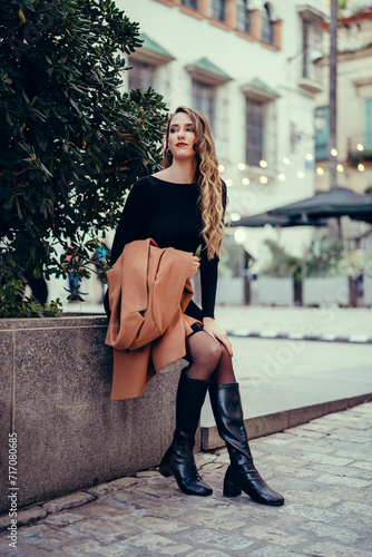 Chica joven con pelo rizado posando en la calle