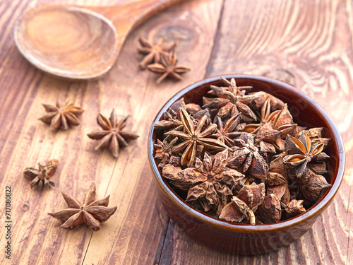 Dried star anise in small brown bowl. photo