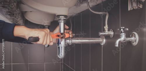 plumber at work in a bathroom, plumbing repair service , fix water plumbing leaks, replace the kitchen sink drain
