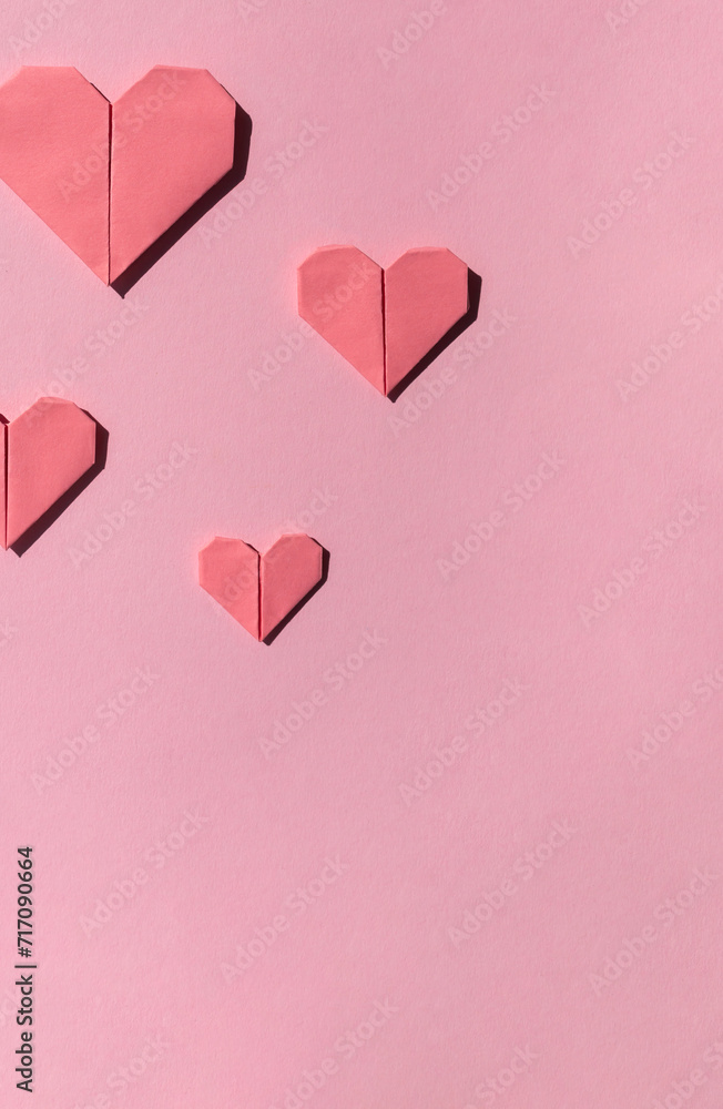 Pink paper origami hearts frame on the pink background. Valentine's day celebration concept. Copy space