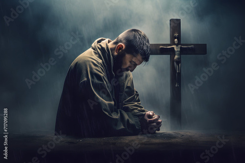 Christian man praying in front of the cross photo