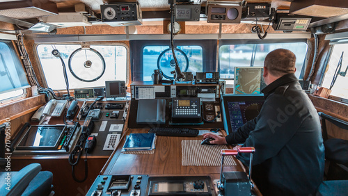 Navigational Bridge of a Modern Military Vessel Featuring Advanced Communication Equipment and Ship Controls photo