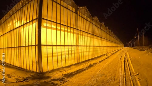 a modern greenhouse taken close up at night in the frosty season of the year
