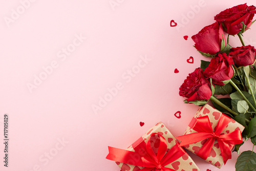 Valentine's day gift bestowal. Top view photo of gift boxes, red hearts, roses on pastel pink background with advertisement zone