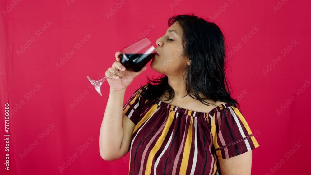 Elegant woman holding a glass of red wine drinking Elegant woman holding a glass of red wine drinking