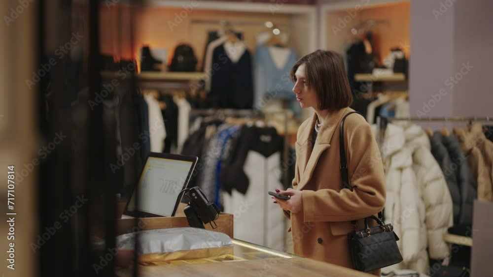 Pay By Phone And Cashless Wallet, Lady Shopper Applying Smartphone To Pos-Terminal In Clothing Store Pay By Phone And Cashless Wallet, Lady Shopper Applying Smartphone To Pos-Terminal In Clothing Store