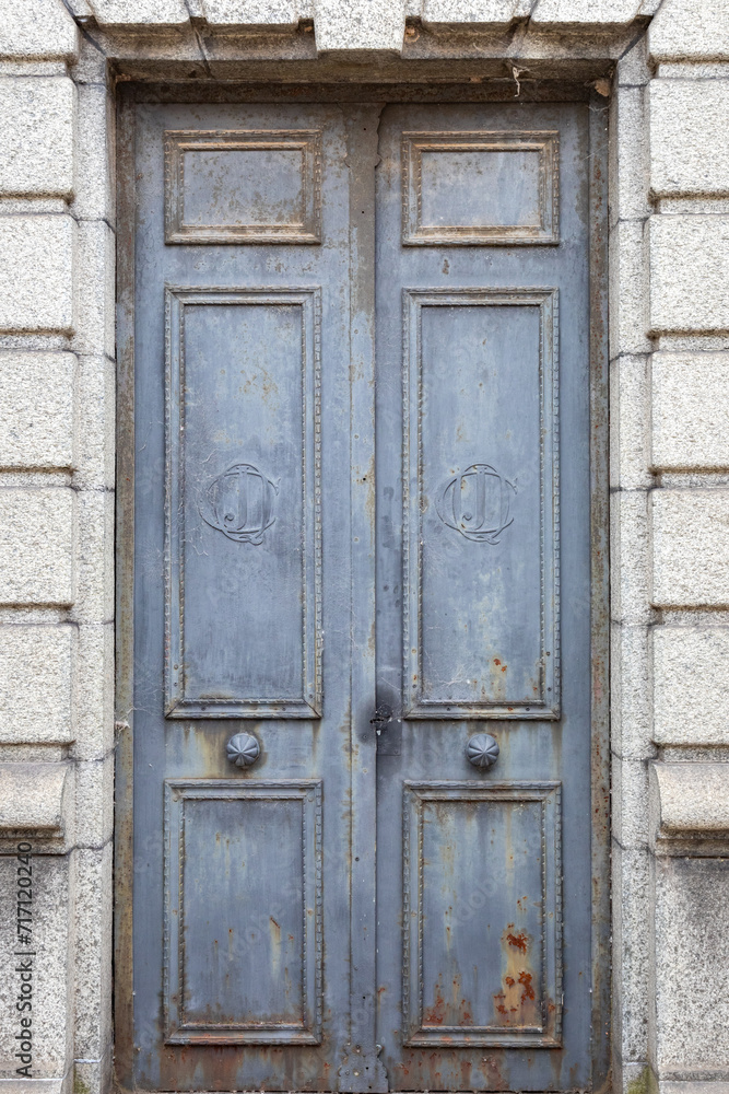 A Weathered Blue Paneled Wooden Door in a Crypt in Recoleta Cemetery, Buenos Aires, Argentina A Weathered Blue Paneled Wooden Door in a Crypt in Recoleta Cemetery, Buenos Aires, Argentina