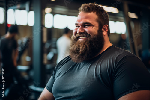 Bearded man smiling in the gym, reflecting a positive spirit and a healthy lifestyle.