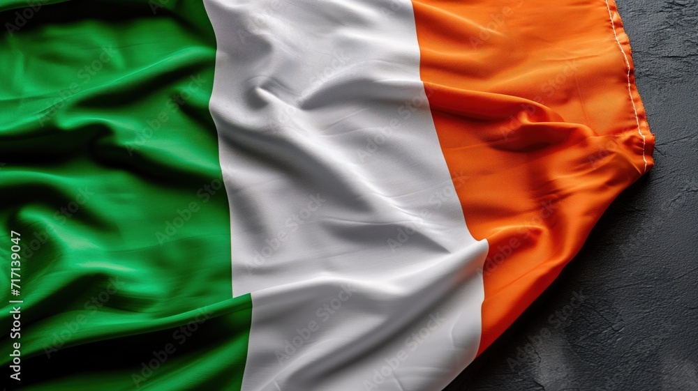 Irish flag draped over a rough dark background Irish flag draped over a rough dark background