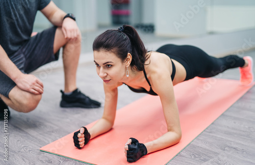 Woman Performing Push Ups on Yoga Mat for Fitness Training. A woman is energetically doing push ups on a yoga mat as part of her fitness training routine.