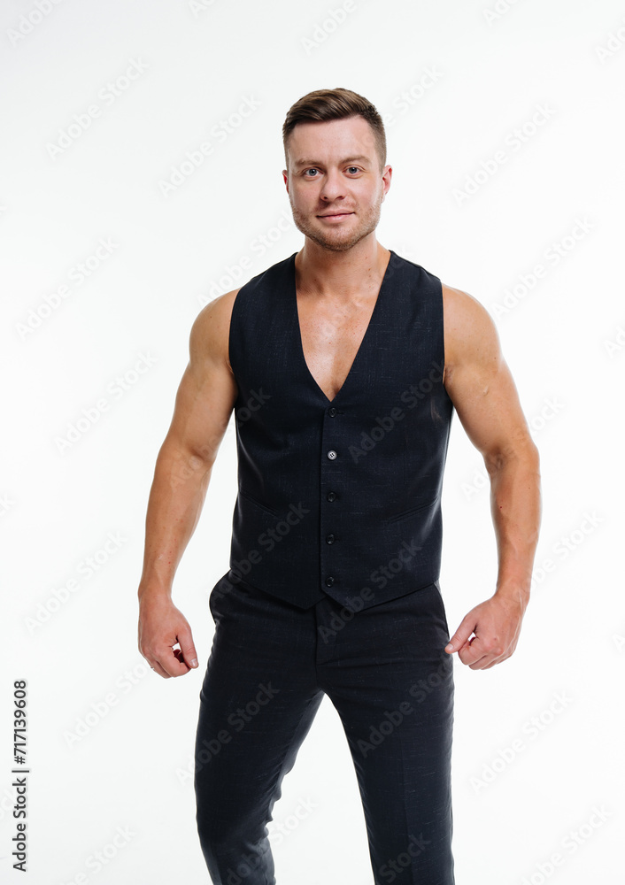 Man in Black Vest Poses for Picture Against a Neutral Background. A stylish man wearing a black vest strikes a pose against a plain backdrop, ready for a photoshoot. Man in Black Vest Poses for Picture Against a Neutral Background. A stylish man wearing a black vest strikes a pose against a plain backdrop, ready for a photoshoot.