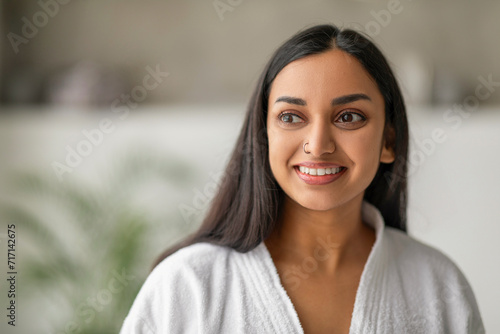 Attractive eastern lady in bathrobe looking at copy space