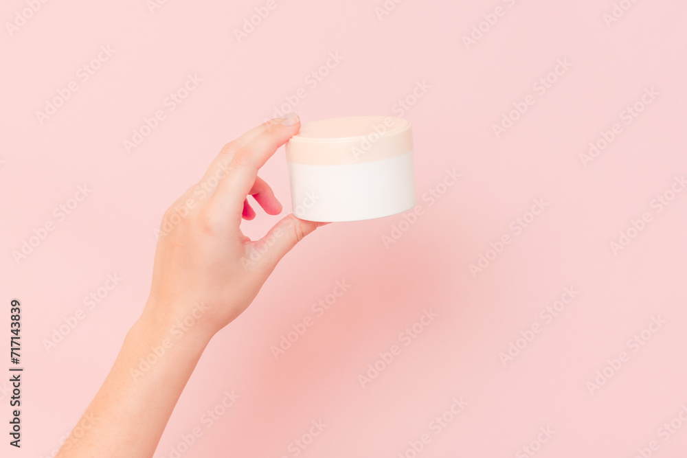 Round jar of cosmetic cream in hand on pink background. Cosmetics beauty mockup for product branding Round jar of cosmetic cream in hand on pink background. Cosmetics beauty mockup for product branding