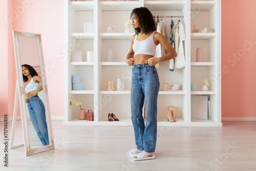 Canvas Print Woman in jeans frowns at her reflection, concerned about weight
